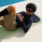 Mini tapis de sol pad de confort de la marque hercule studio modèle galé couleur outrenoir posé sur le tapis d'exercice archy couleur pistache avec mannequin allongé dessus