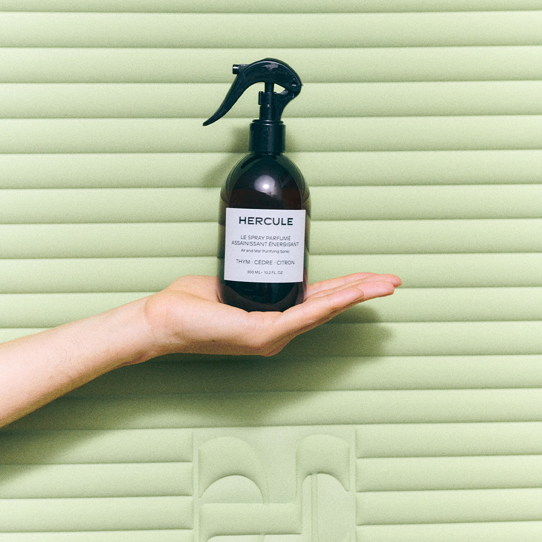 Spray pour assainir le tapis de sport et énergiser l'espace d'entraînement photo du produit devant le tapis archy pistache tenu dans la main