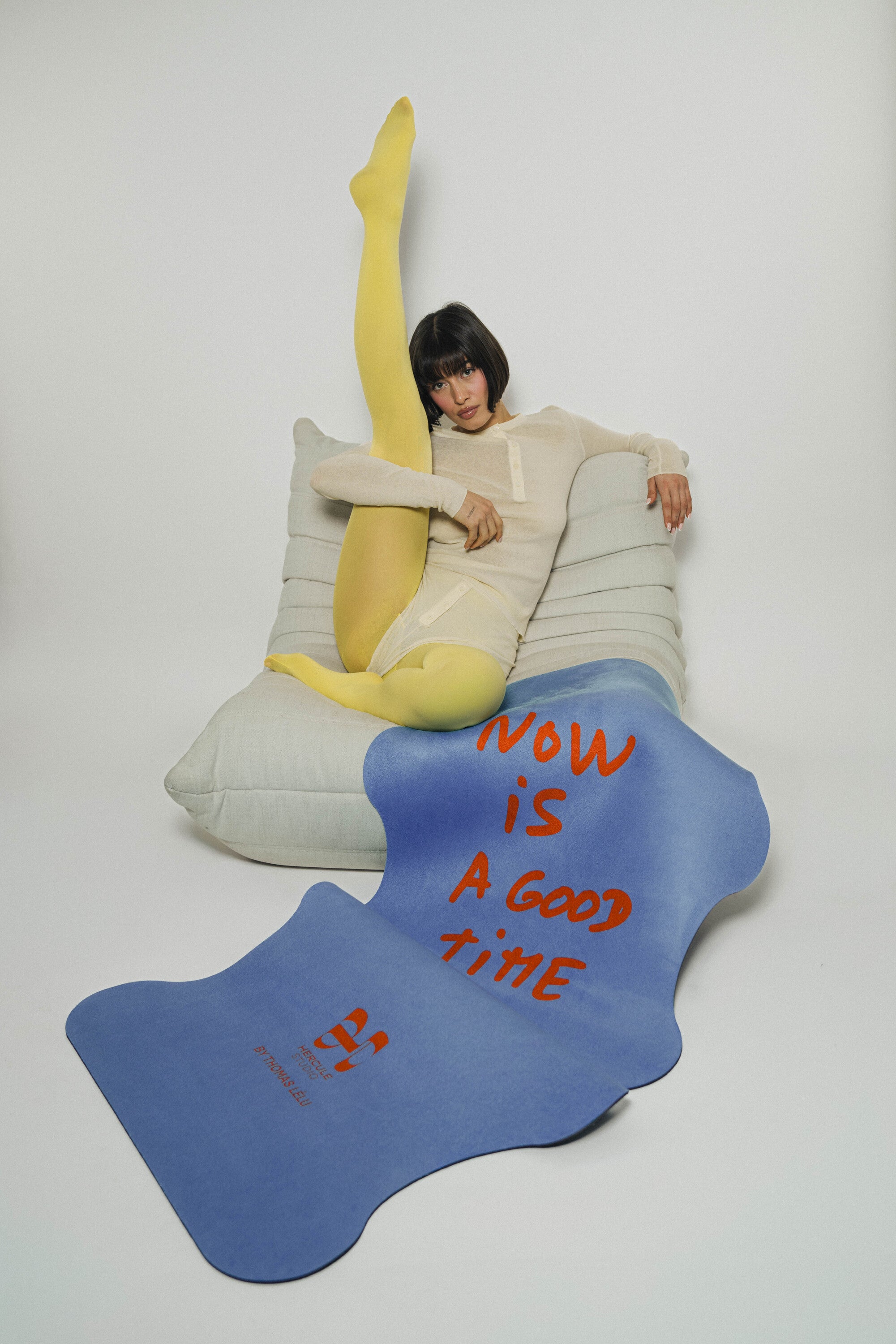 Mise en situation lifestyle design du tapis de yoga Hercule Studio x Thomas Lélu avec la citation "Now is a Good time" imprimée dessus