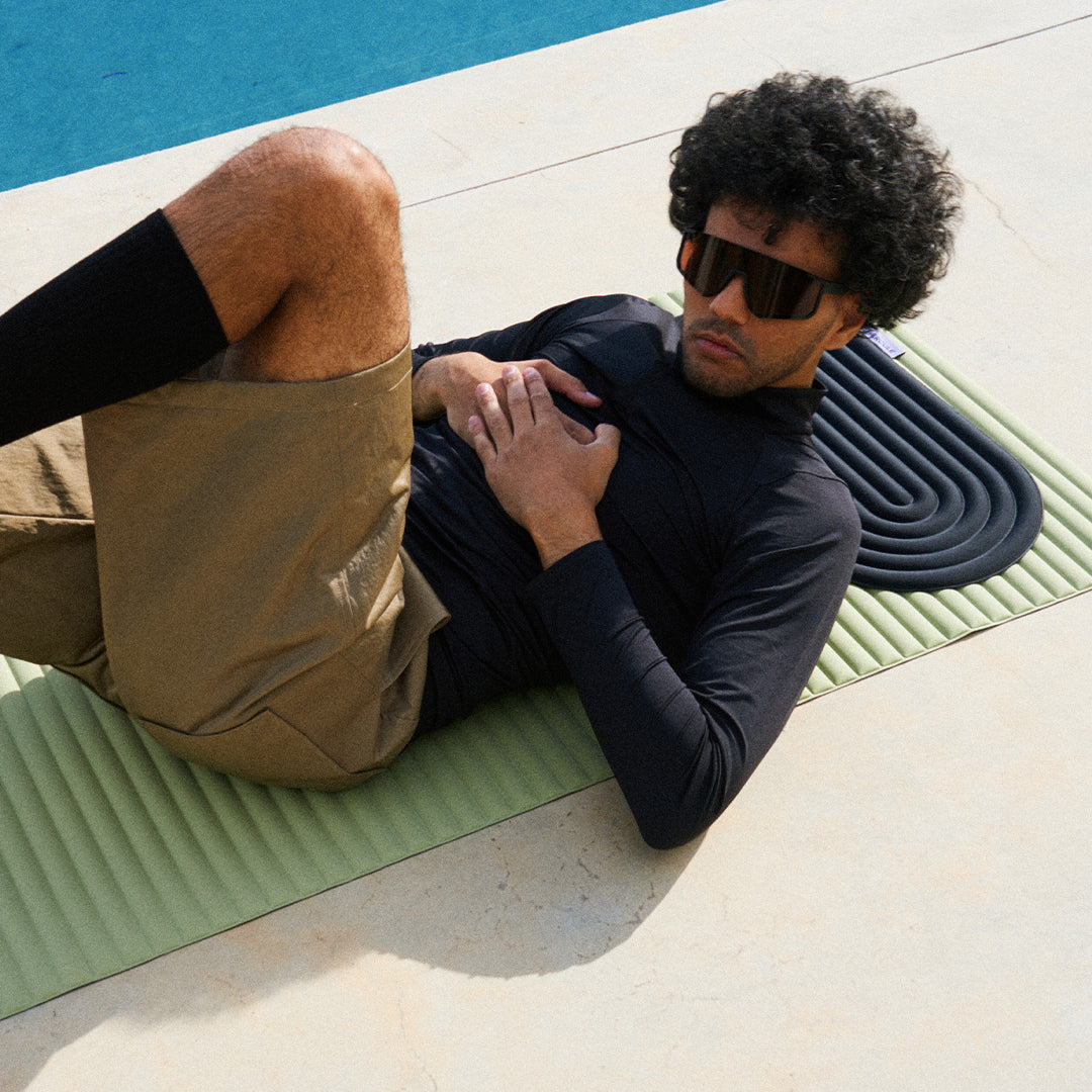Mini tapis de sol pad de confort de la marque hercule studio modèle galé couleur outrenoir posé sur le tapis d'exercice archy couleur pistache avec mannequin allongé dessus