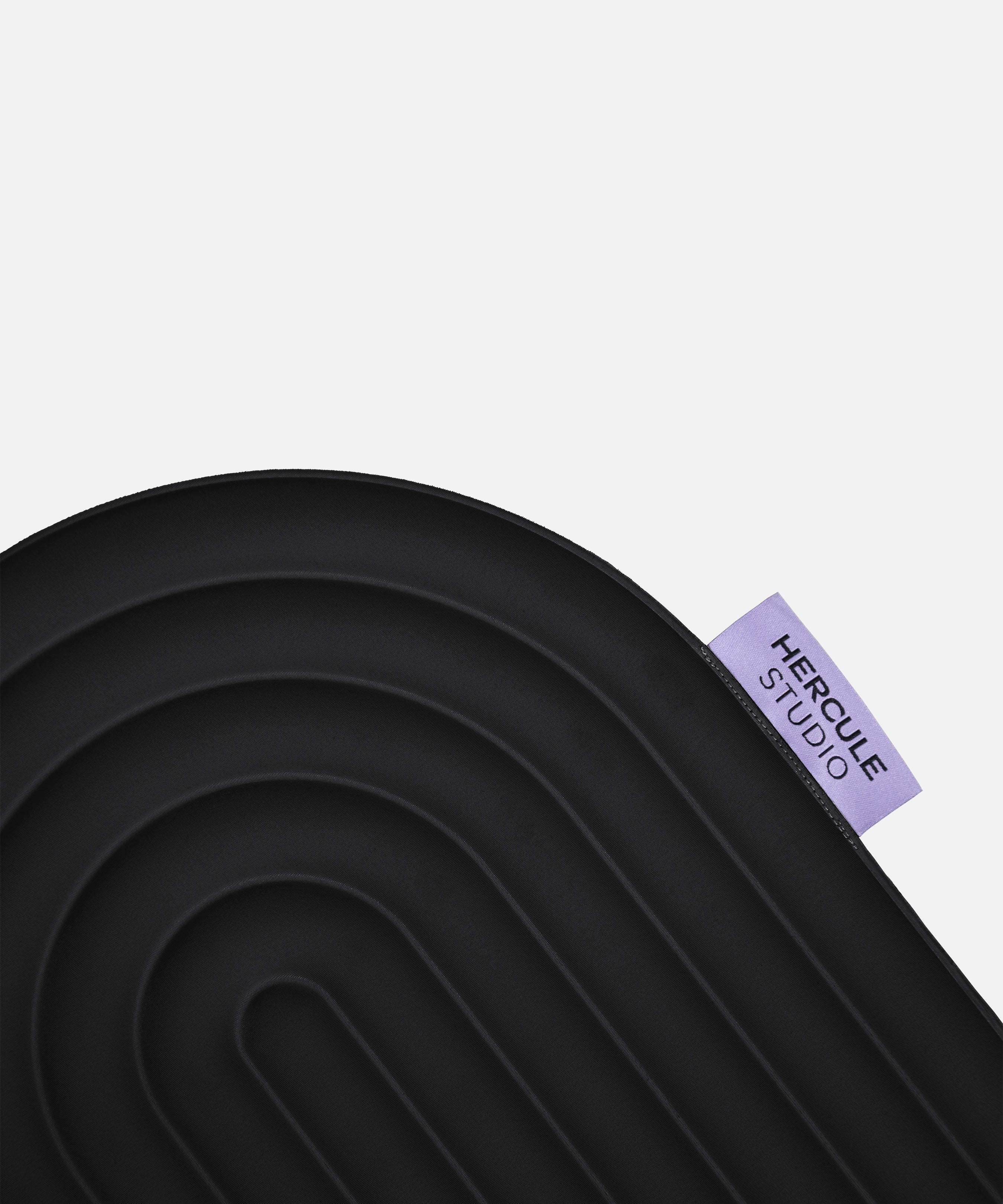 Étiquette violette du mini tapis Galé Hercule Studio avec logo noir – pad innovant 3‑en‑1 noir (Outrenoir), support ergonomique zones sensibles, design français durable