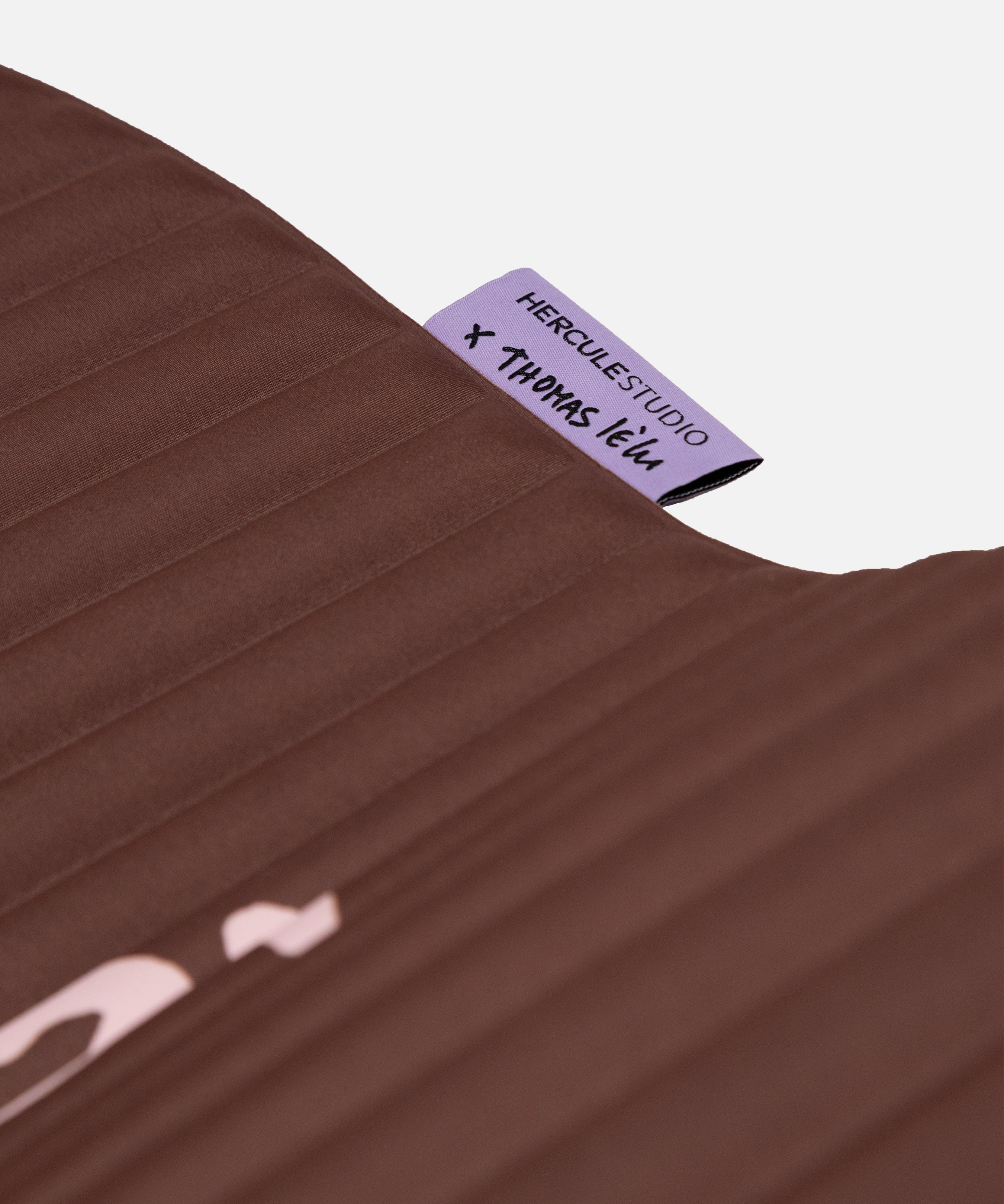 Close-up on the custom Hercule Studio x Thomas Lélu label, premium textile finish of the sport mat