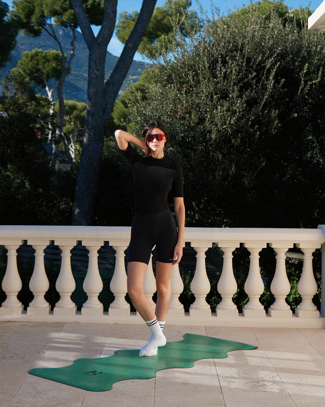 Hercule Studio yoga mat, “Mar” model in golf green, photo showing a model standing on the mat
