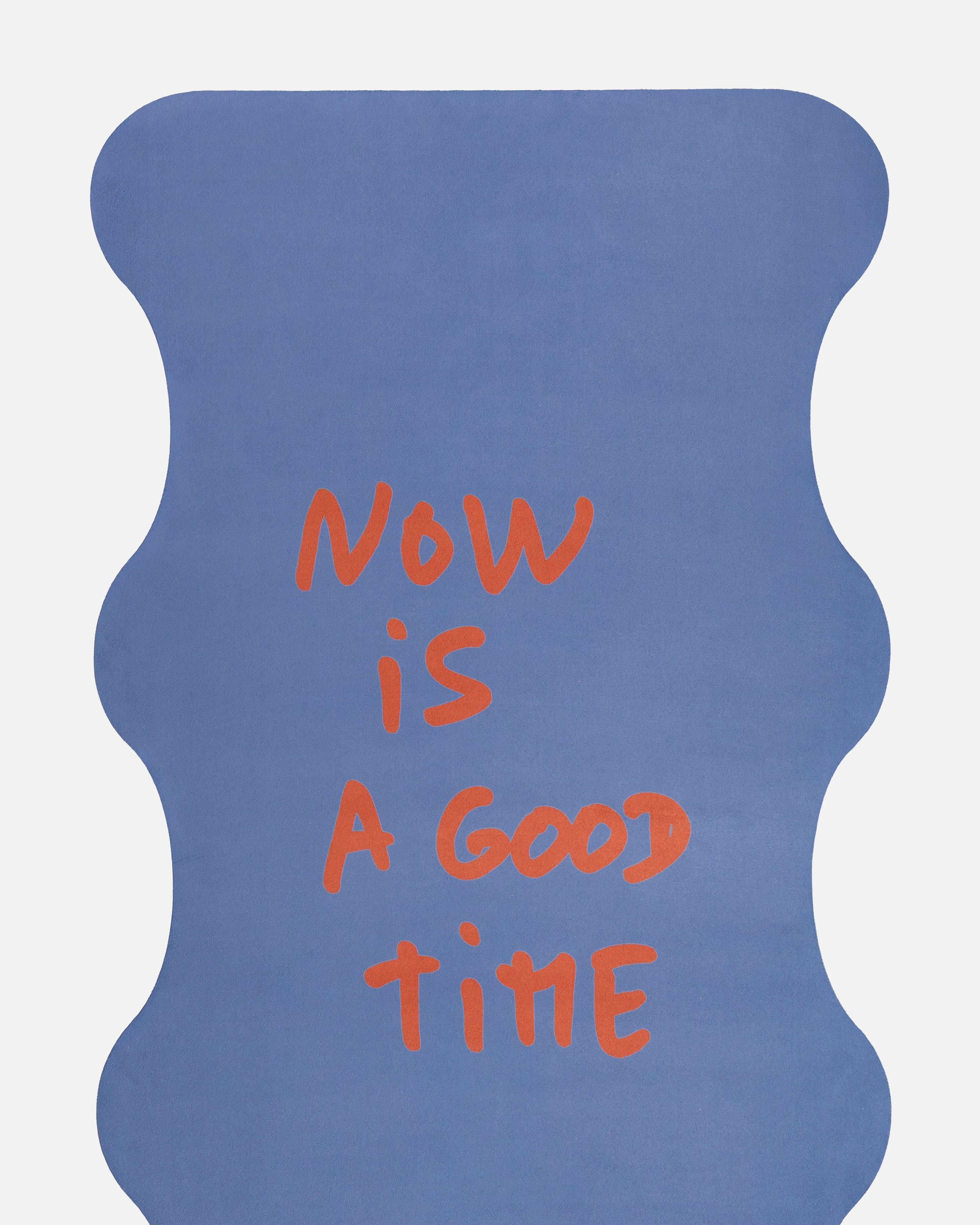 Close-up of the quote “Now is a good time” on the Hercule Studio x Thomas Lélu yoga mat, featuring an inspiring red message on a blue background